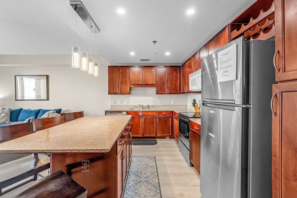 Modern kitchen with stainless steel appliances and a spacious island for dining.