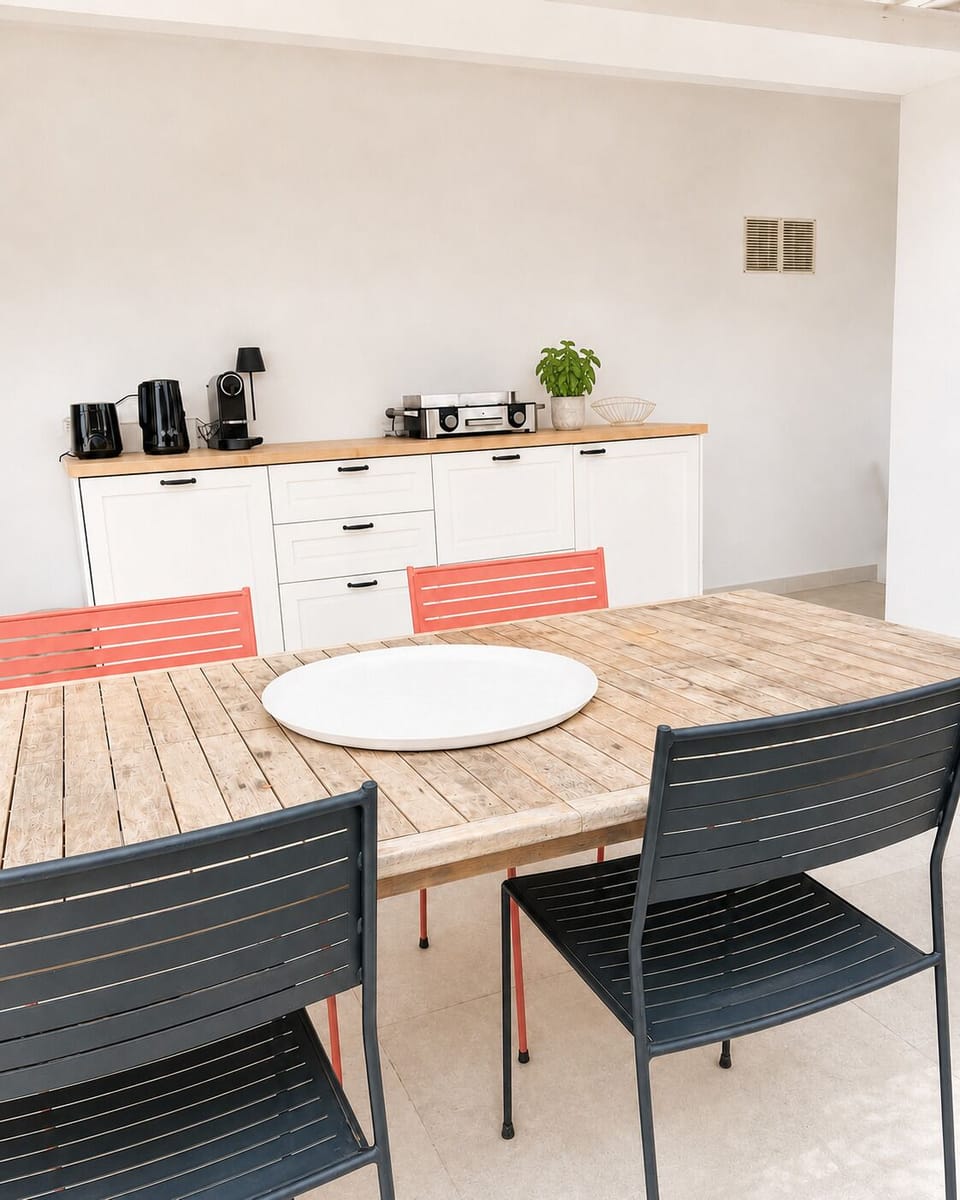 Dining area with extendable table, seating four comfortably — coffee machine and toaster included.