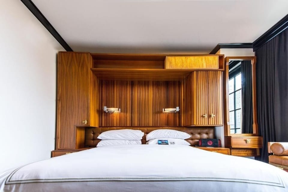 Unwind in crisp linens beneath warm, bespoke wood paneling.