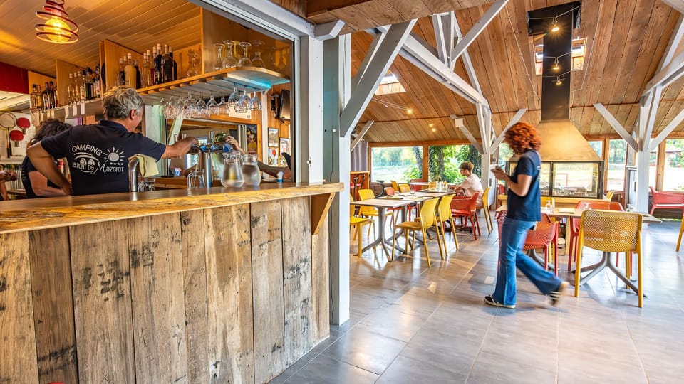 The inviting bar area features rustic wooden decor and colorful seating, where families can enjoy refreshing drinks in a cheerful atmosphere.