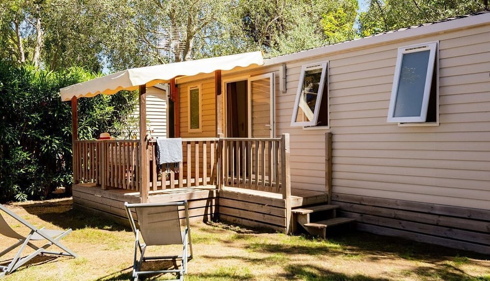 Experience the charm of a mobile home nestled amidst lush greenery.
