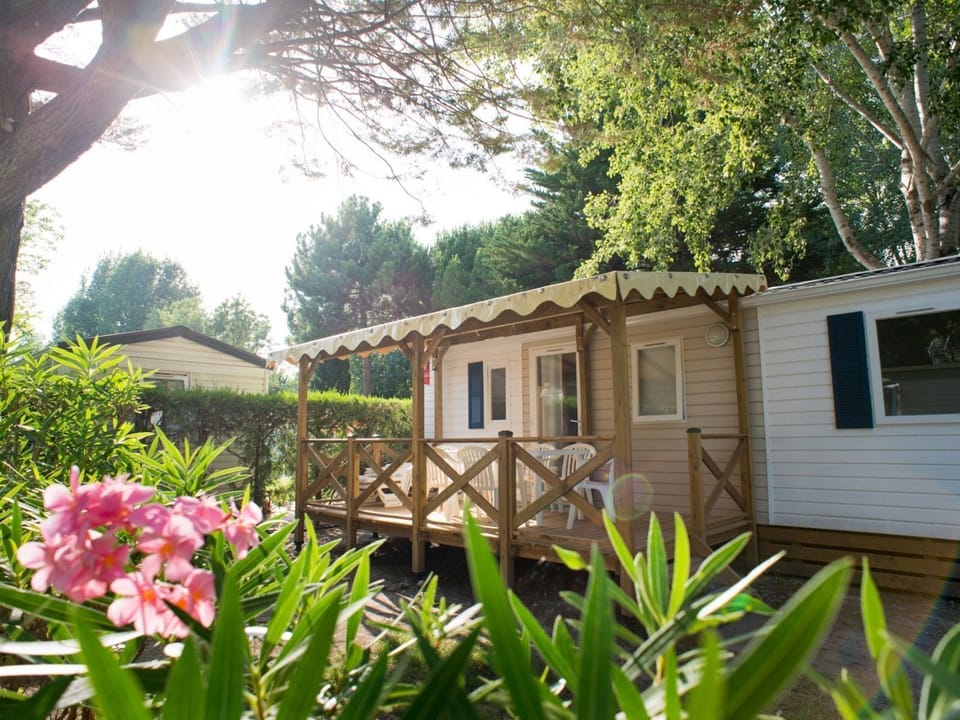 Enjoy the beauty of nature with this mobile home nestled in a lush, floral setting.