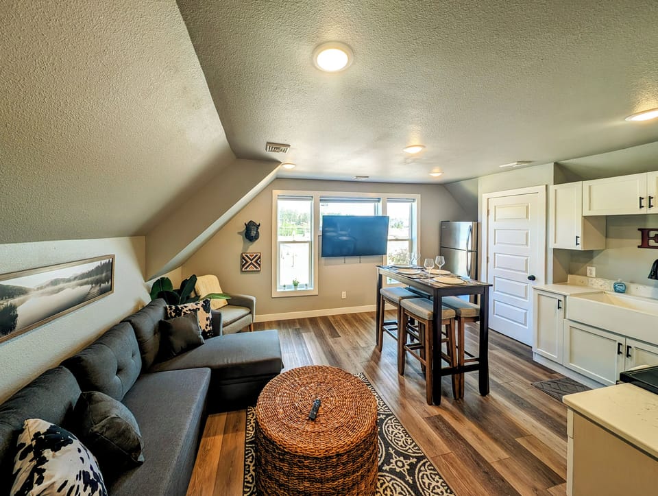 Upstairs 1BR, 1BA apartment with smart TV, couch, pub table, and full kitchen.