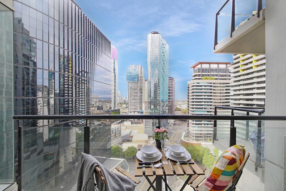 A balcony with a setting & city views.