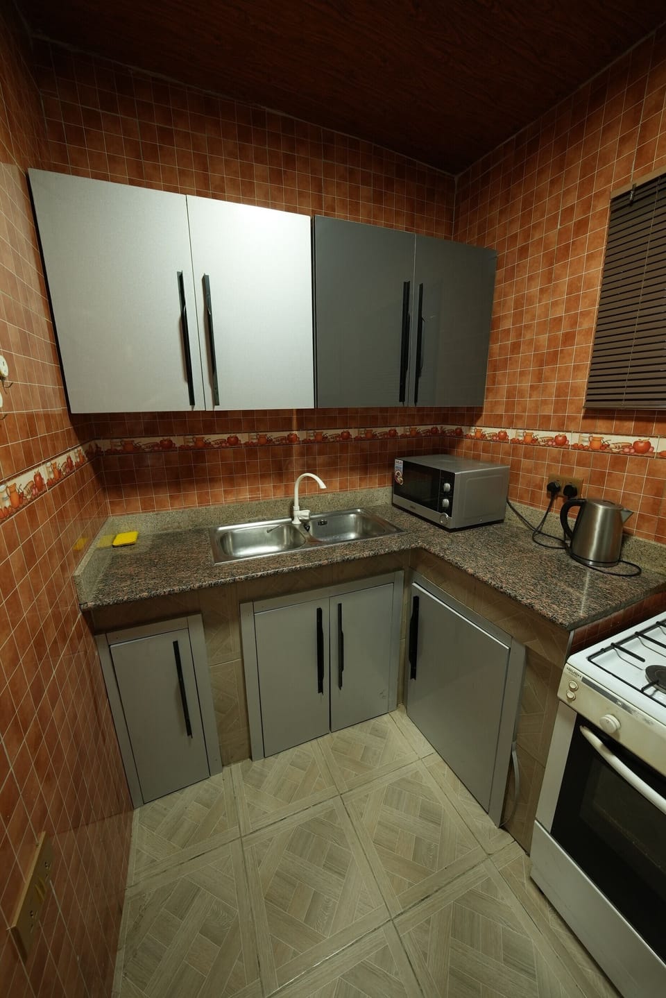 Modern kitchen with kettle, microwave, stove and oven.