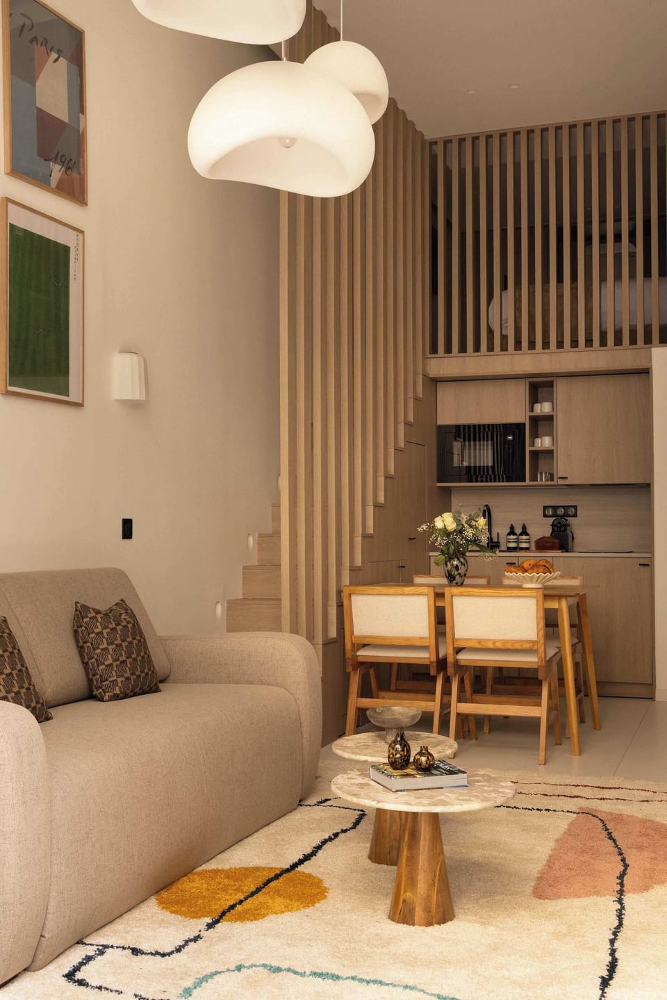 Salon avec canapé lit, TV, espace repas pour 4 personne et cuisine ouverte
