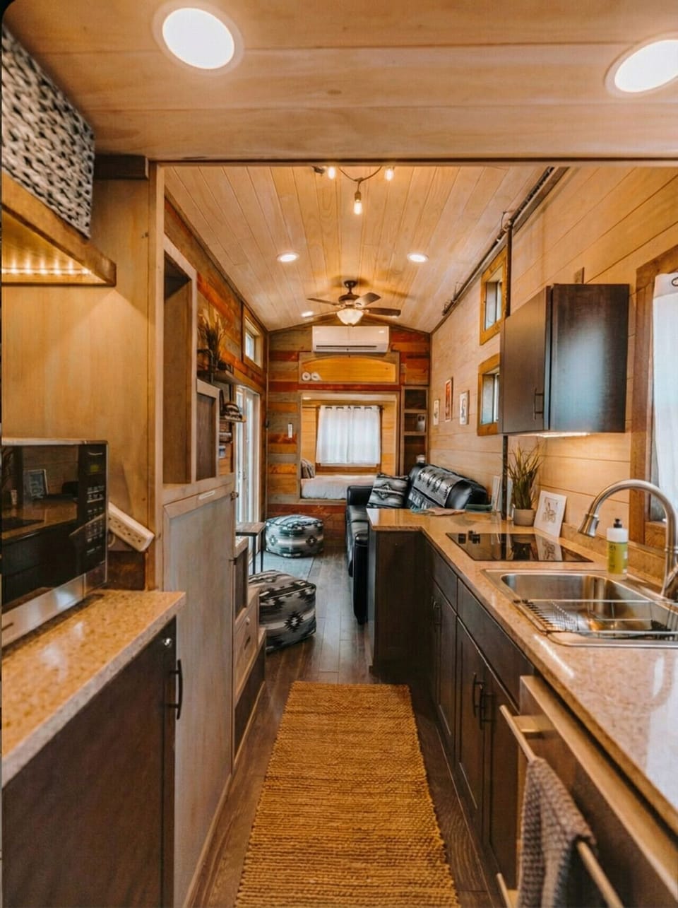 One continuous space flows from kitchen to living room to a cozy bedroom nook — smart, efficient tiny living.