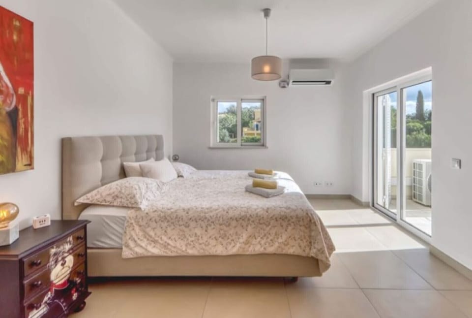 Air-conditioned bedroom with double bed and glass door to the balcony on the first floor of Villa Larissa