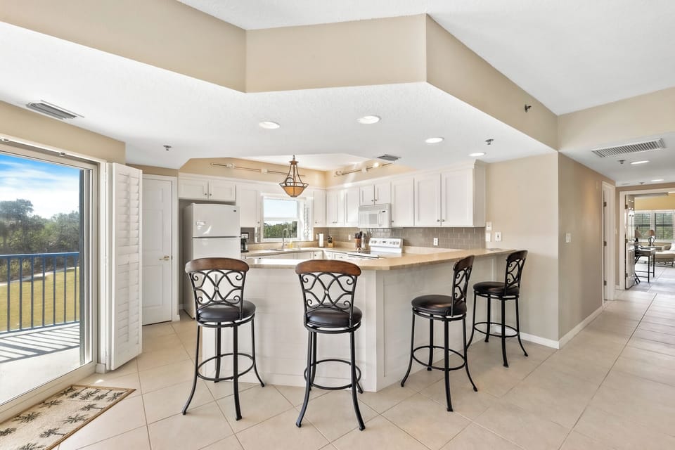 The kitchen features a bar area for guests to hangout at