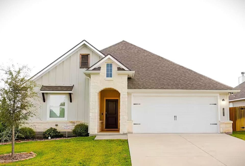 Nestled in a quiet neighborhood, this inviting home offers a welcoming entrance with its blend of classic stone and modern accents.