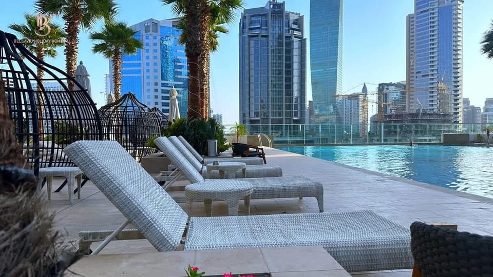 A few potted palms stand at the edges, their leaves swaying gently. Beyond the pool, you see a backdrop of bright sky and maybe distant greenery or ocean, depending on the setting you want. The whole scene feels open, warm, and relaxing.