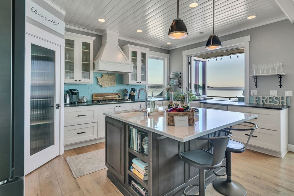 Bright designer kitchen with island seating and stunning water views