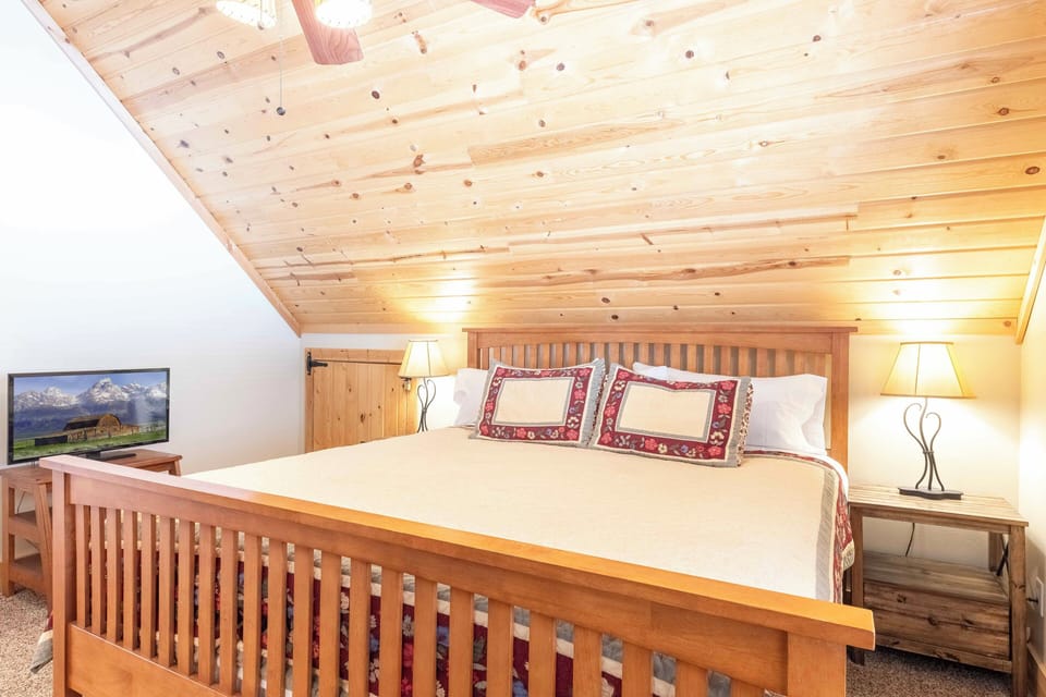 Master bedroom with king size bed and tv 