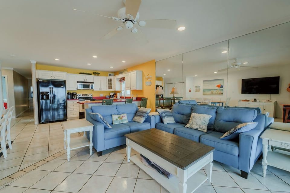 Living room with pull out sofa, loveseat.  Ceiling fan and tile floors.