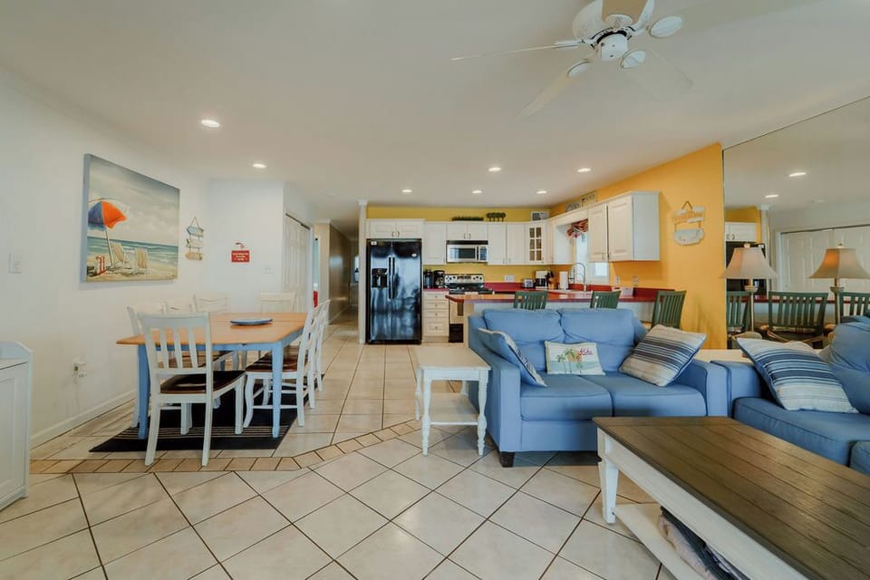 Living room with pull out sofa, loveseat.  Ceiling fan and tile floors.