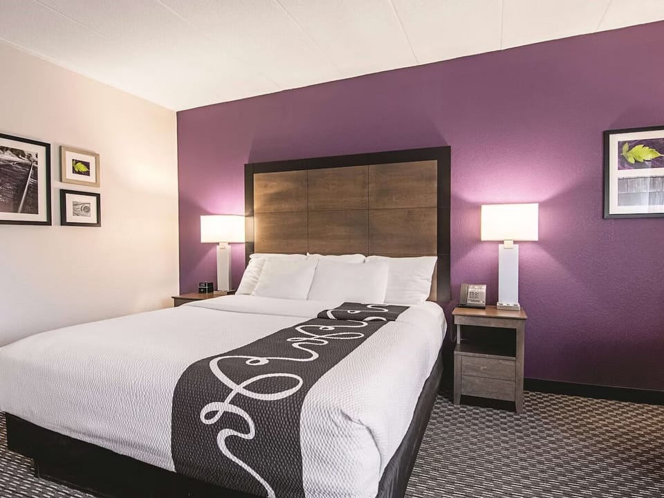 Drift off in a plush king bed framed by warm lamps.