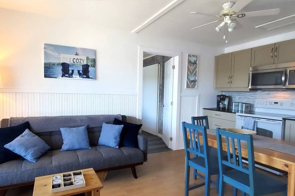 Living room with kitchen to right and pull-out couch for additional sleeping space