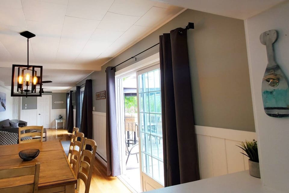 Vue sur la salle à manger et de la salle de séjour depuis la cuisine. - dining area with patio door opening out onto deck
