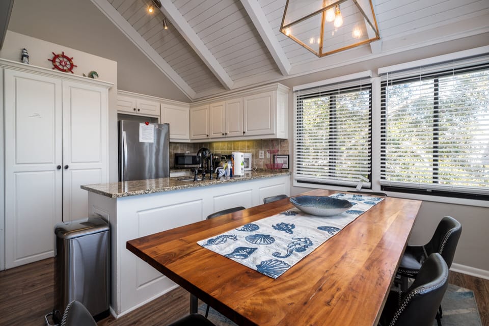 The kitchen and dining area sit under ship-lapped vaulted ceilings