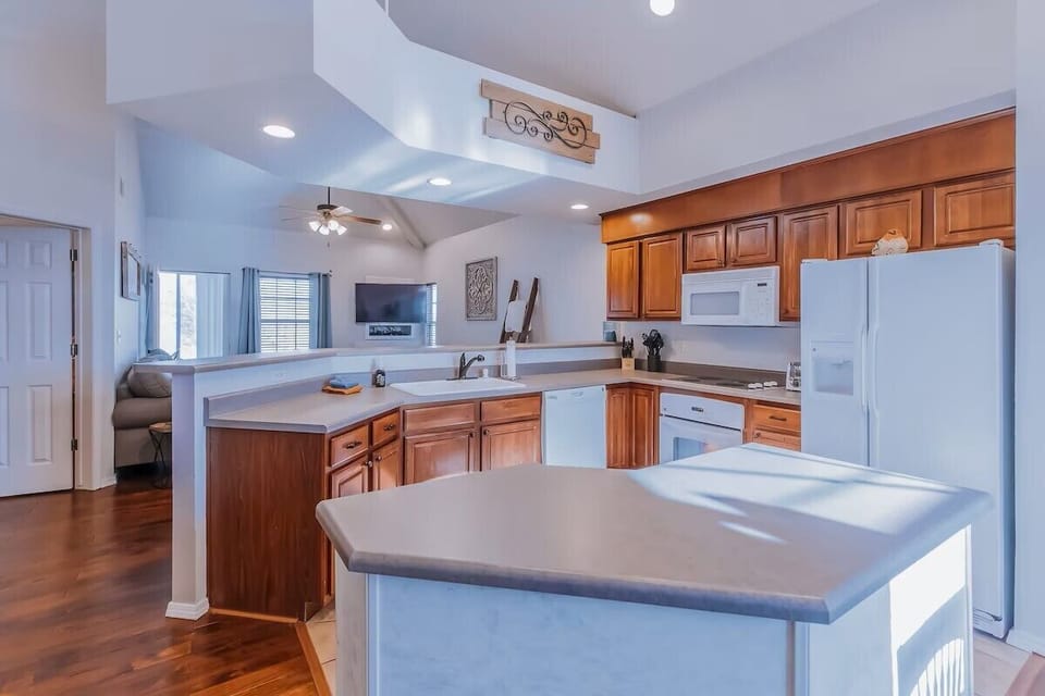 Open kitchen has full-sized appliances, seating at bar and open to dining area