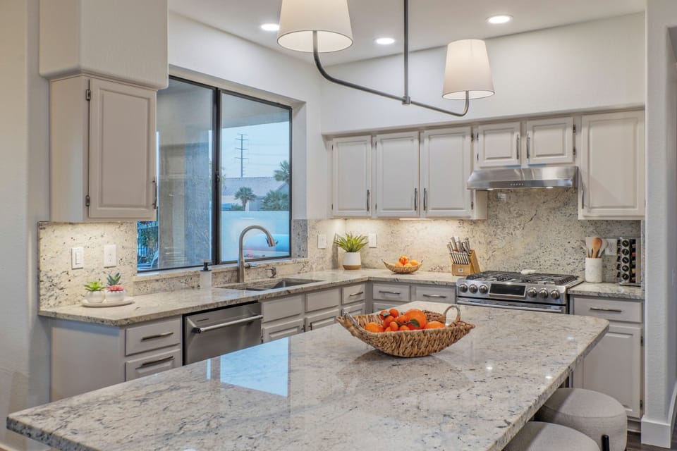 Modern kitchen has beautiful counters for serving eats and treats.