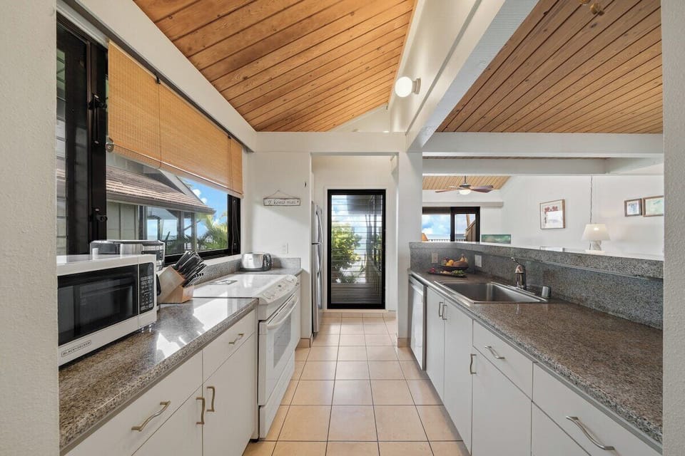 Upgraded kitchen with granite countertops, stainless steel appliances, and a large prep island ideal for Maui vacation cooking.
