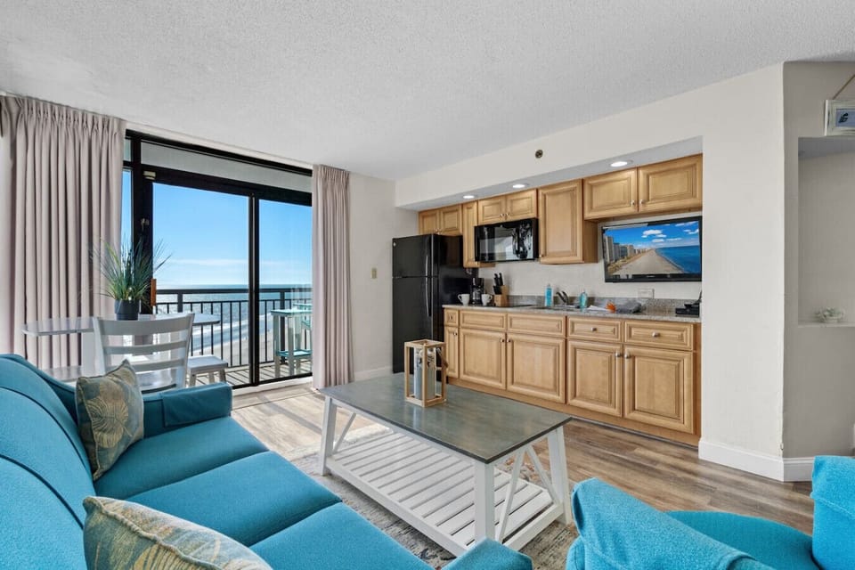 The living room features a full sofa with a queen sleeper, a fully equipped kitchen, and oceanfront views, some of the best in North Myrtle Beach. Step onto the balcony to see stunning resort pools, as well sunrises and sunsets over the ocean.
