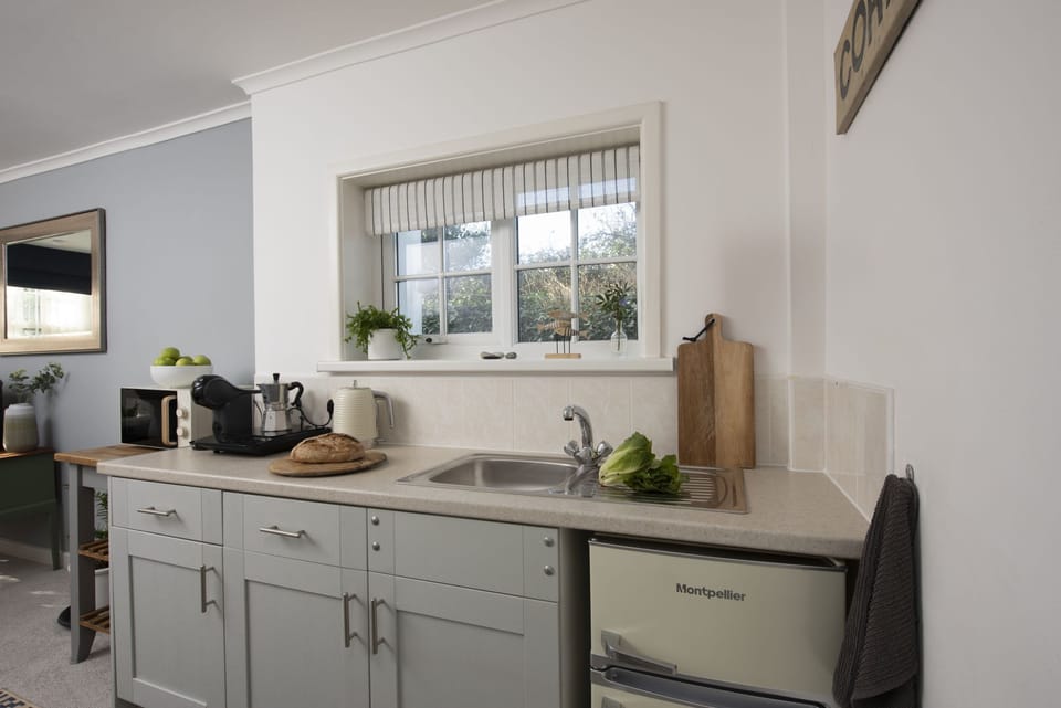 Kitchen with electric hot plate, microwave, fridge freezer, kettle, toaster, Nespresso coffee machine and a range of pans and utensils - Olive Cottage by Stay Ca Holidays