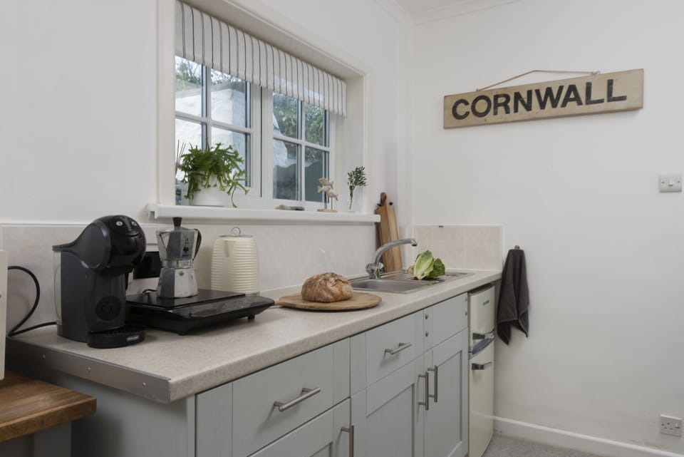 Kitchen with electric hot plate, microwave, fridge freezer, kettle, toaster, Nespresso coffee machine and a range of pans and utensils - Olive Cottage by Stay Ca Holidays