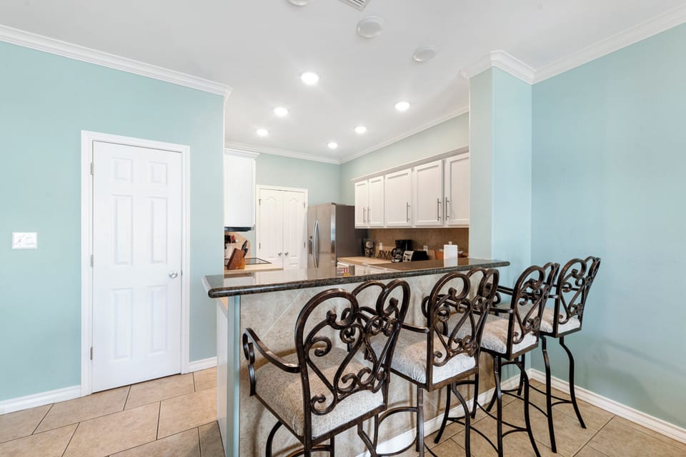 Your open kitchen features granite countertops and elegant bar seating, perfect for morning coffee or casual meals together.