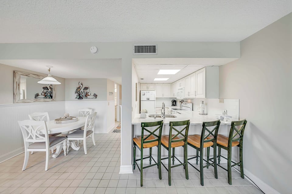 There is a dining table, perfect for enjoying a meal or playing a game, as well as additional breakfast bar seating.