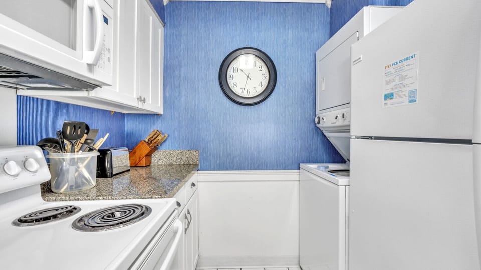 Washer and dryer tucked besides the refrigerator.