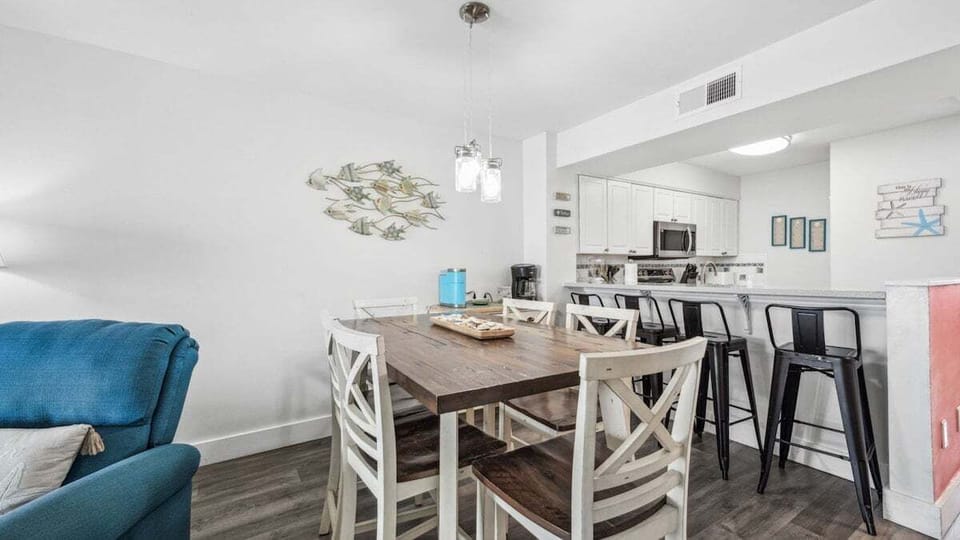 Gather around the rustic dining table or enjoy casual seating at the breakfast bar in this bright, beachy dining space. Ideal for family meals or relaxed conversations.