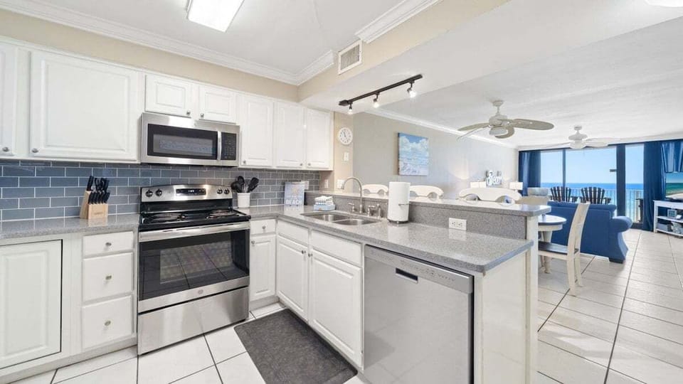 Cook with a View. This fully equipped kitchen features stainless steel appliances, tile backsplash, and an open layout overlooking the Gulf.