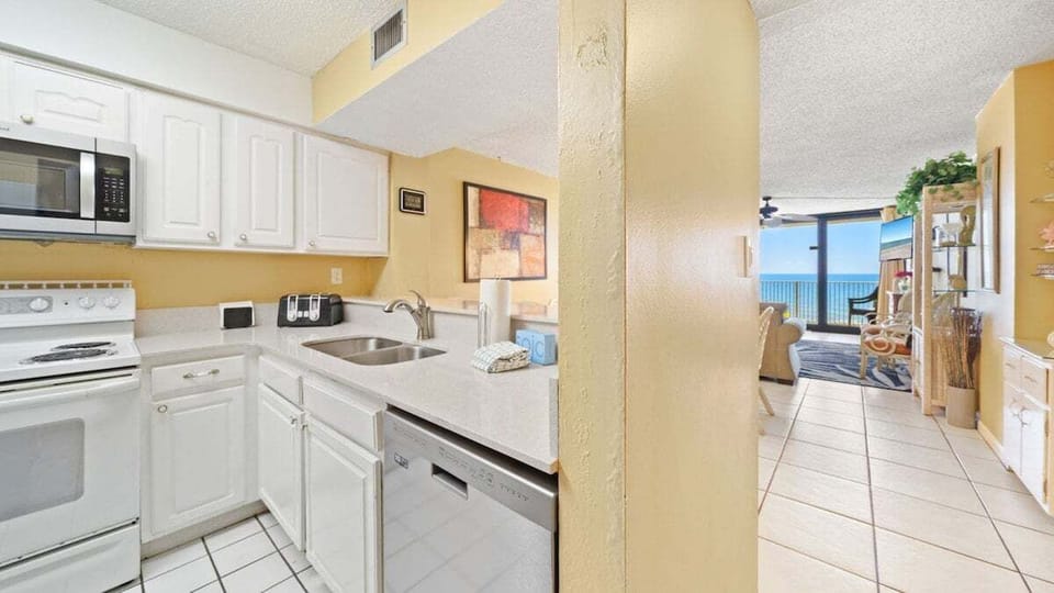 This bright and functional kitchen comes fully equipped with everything you need to cook at home, while offering a view that leads straight out to the beach.