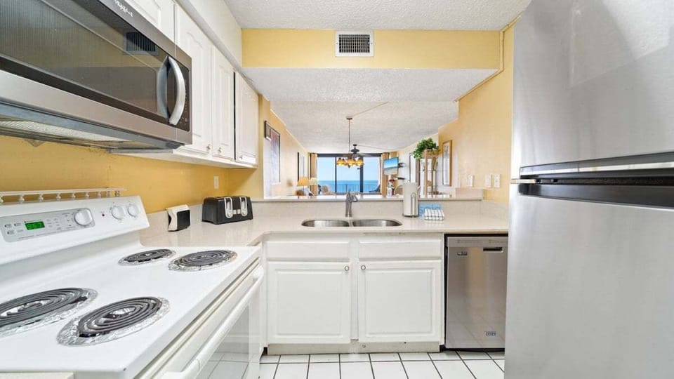 Fully equipped kitchen. Cook with ease using full-size appliances, a dishwasher, and everything you need—all with Gulf views just beyond.