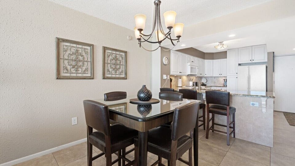 Modern dining space with a sleek glass-top table and leather seating.