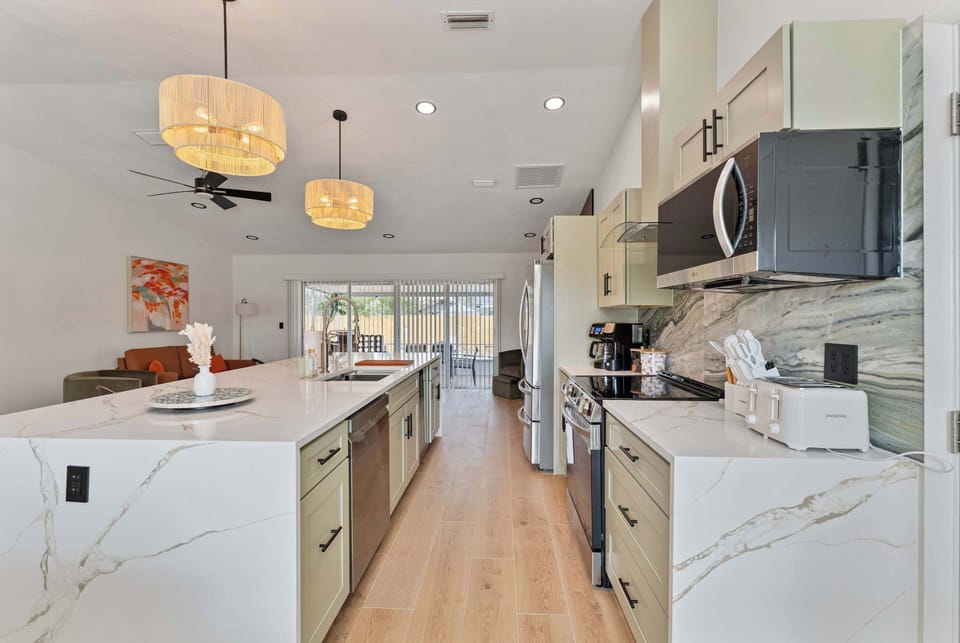 This wide-angle shot highlights the expansive kitchen island, designed for both cooking and casual dining. With ample room for meal preparation, it serves as the heart of the home, surrounded by modern appliances.