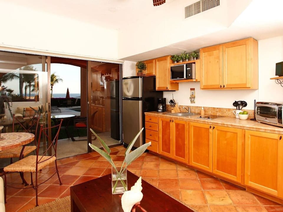Kitchen Close-Up – Functional kitchen with microwave, fridge, toaster oven, and wooden cabinets.