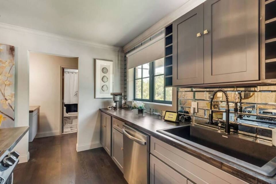 A fully equipped gourmet kitchen with a gas range, stainless steel vent hood, and all the essentials, perfect for entertaining.