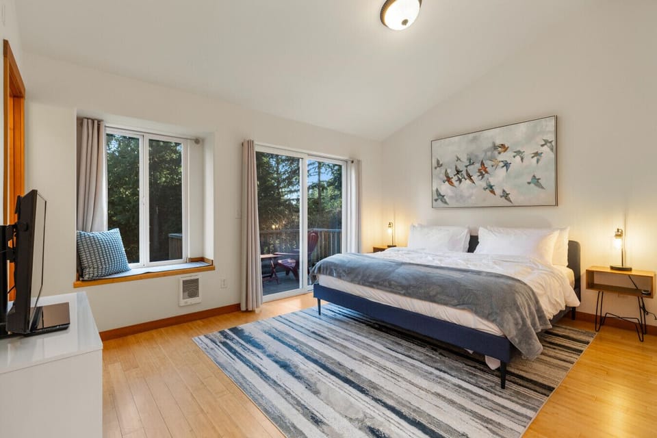 Retreat to the private king bedroom featuring balcony access, natural light, and an attached bathroom