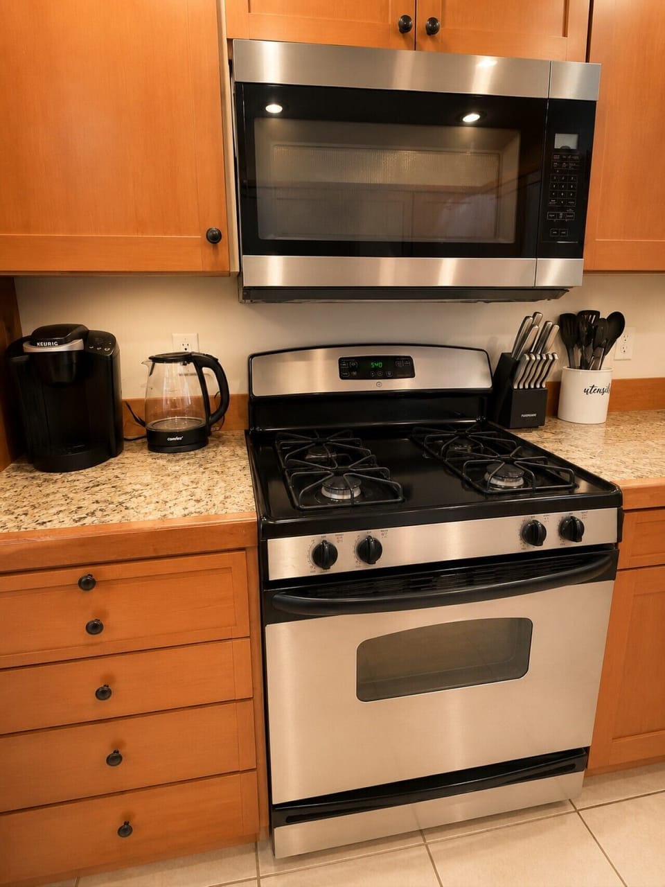 Fully equipped kitchen with gas range, microwave, coffee maker, and kettle