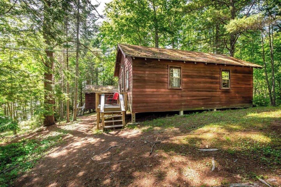 View of Cabin 5 and 6 exterior - each cabin has a porch with shaded canopy and lake views. 