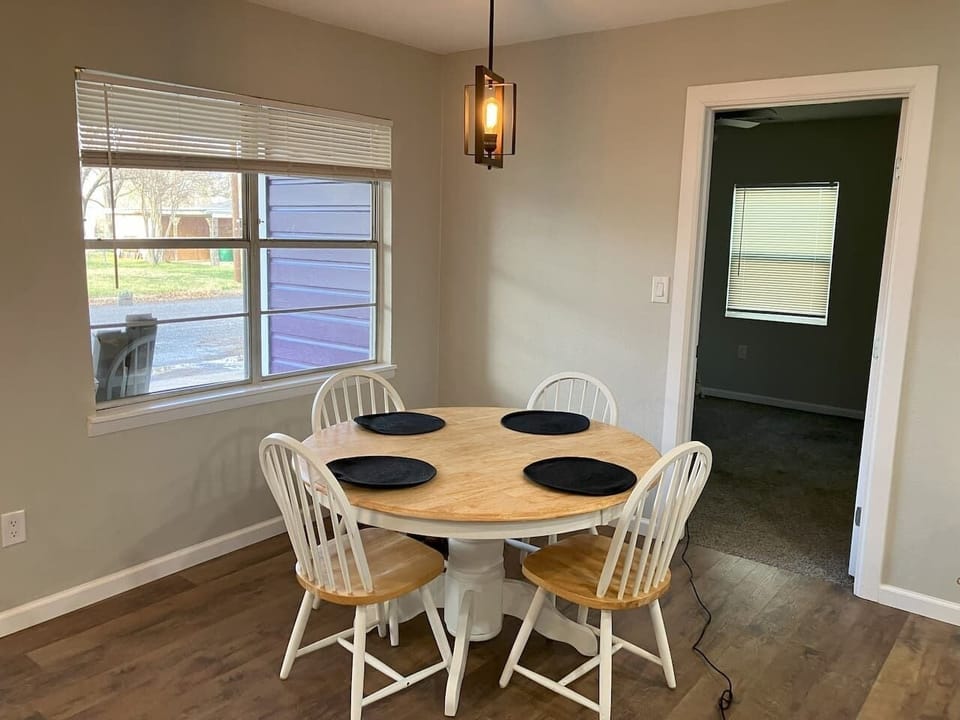 Spacious dining area with a modern table, perfect for enjoying meals or gathering with family and friends during your stay near Tarleton State University in Stephenville.