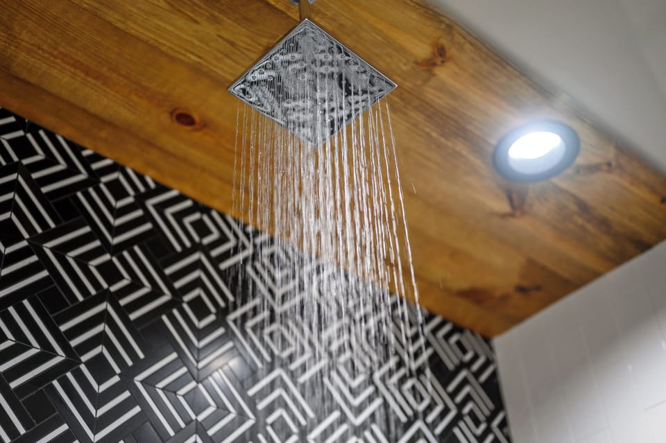 Modern rainfall shower: Relaxation meets bold geometric tile elegance.
