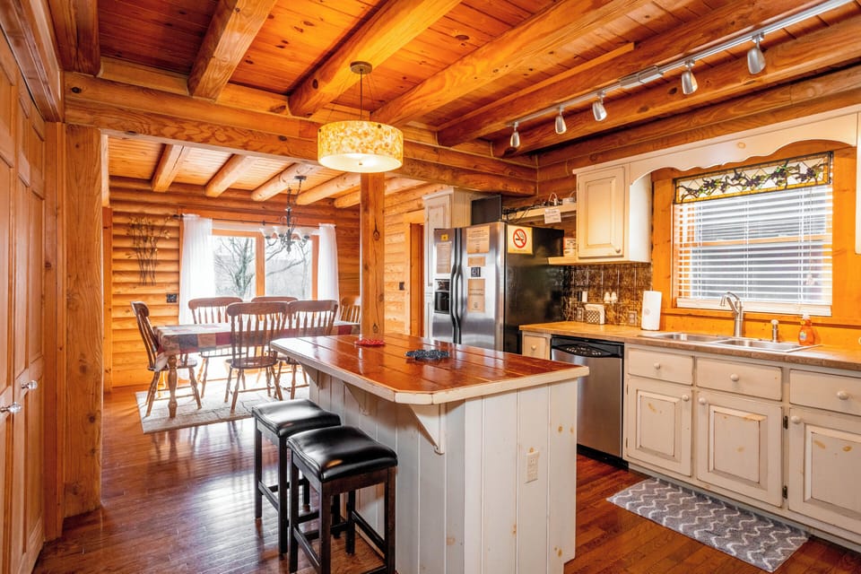 Enjoy meals in this cozy dining nook, surrounded by wood-paneled charm and bathed in natural light from large windows.