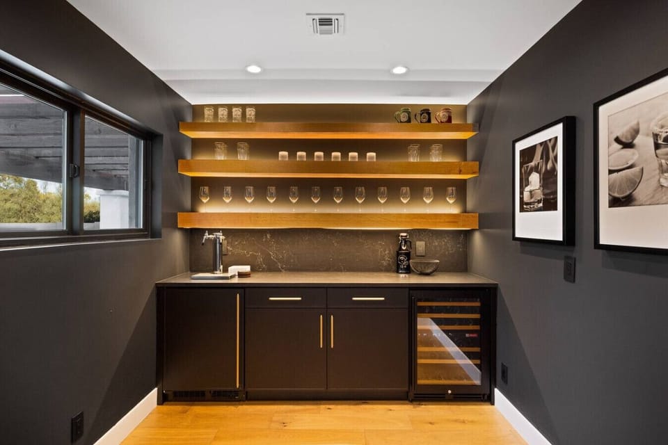 Sleek full bar with wine fridge and backlit shelving—perfect for entertaining.