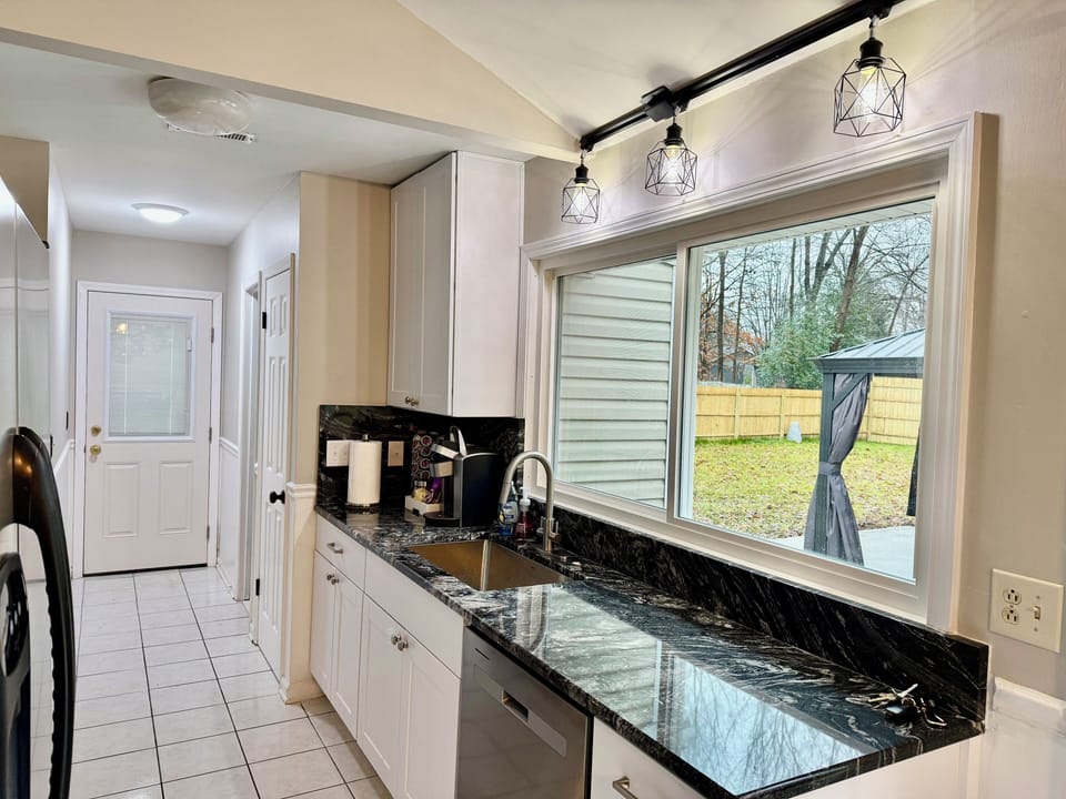 Galley full kitchen with picture window looking at patio.