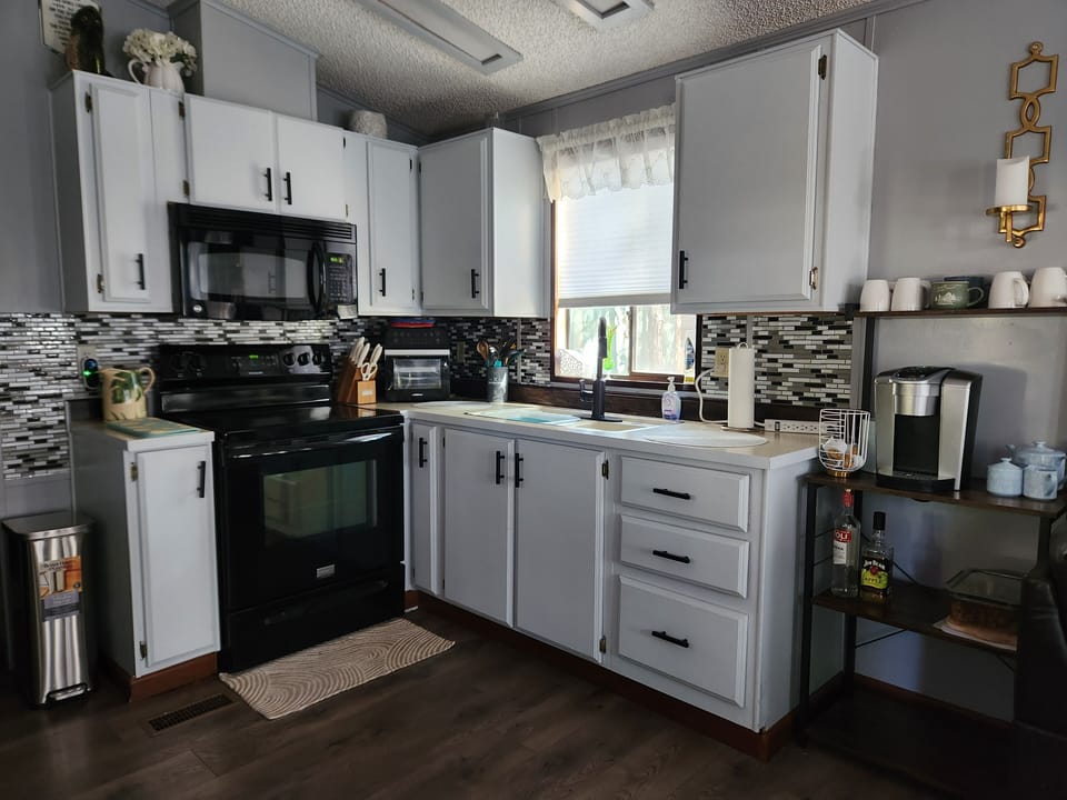 Well stocked kitchen with electric stove and range  and Keurig coffee station