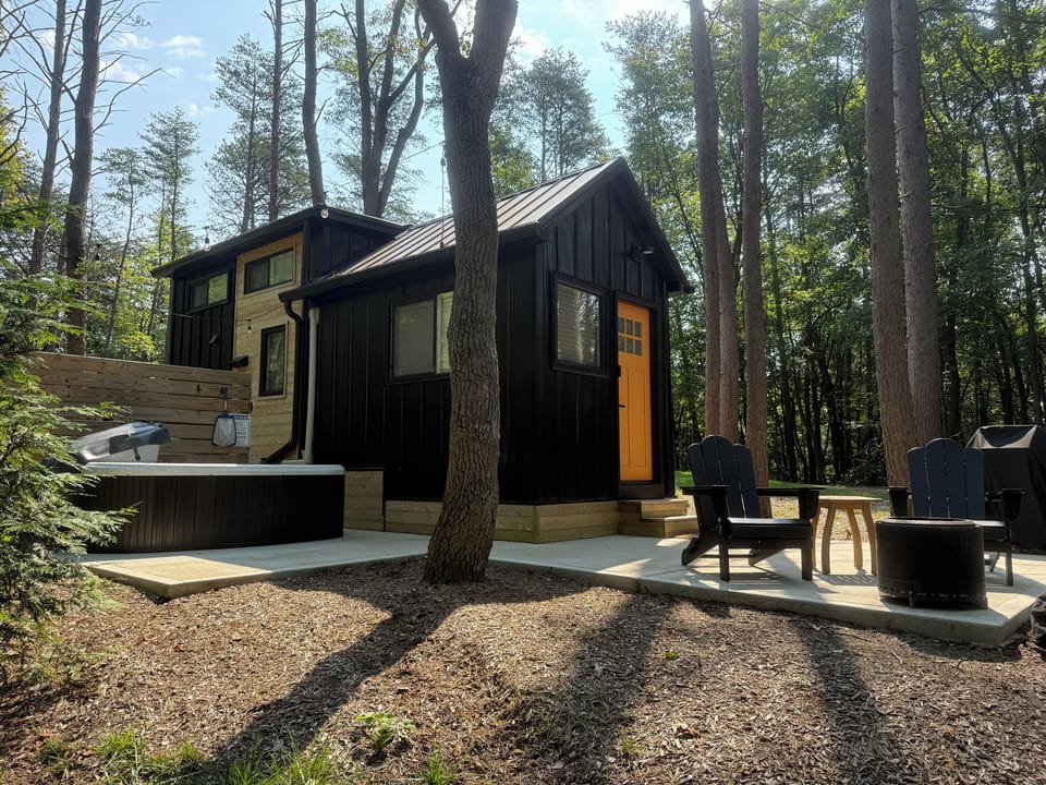 Whitman exterior with hot tub — personal hot tub on the patio, Adirondack seating, wooded setting